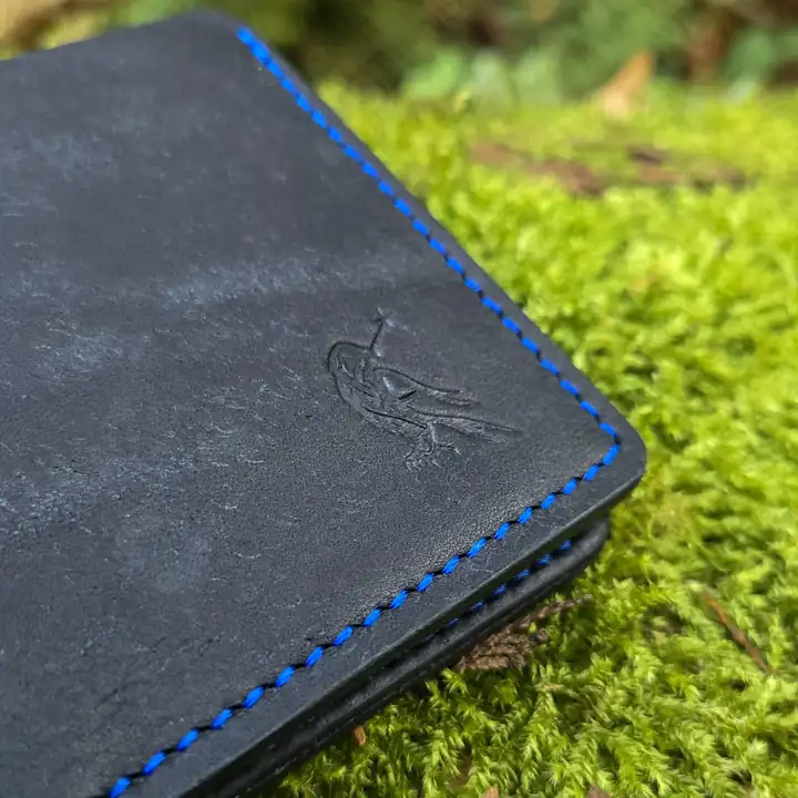 Blue saddle stitch and the embossed raven, up close — Rogue Artisan, East Vancouver