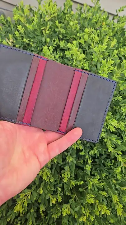 Inside the oxblood bifold — grey and red card slots, navy stitching — Rogue Artisan, East Vancouver