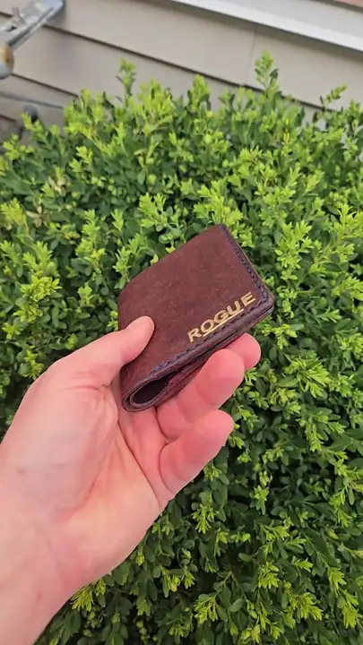 Gold-stamped corner of the oxblood bifold in hand — Rogue Artisan, East Vancouver